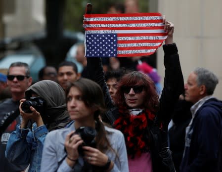 A counter-protester holds a flag after a Proud Boys rally in Portland, Oregon