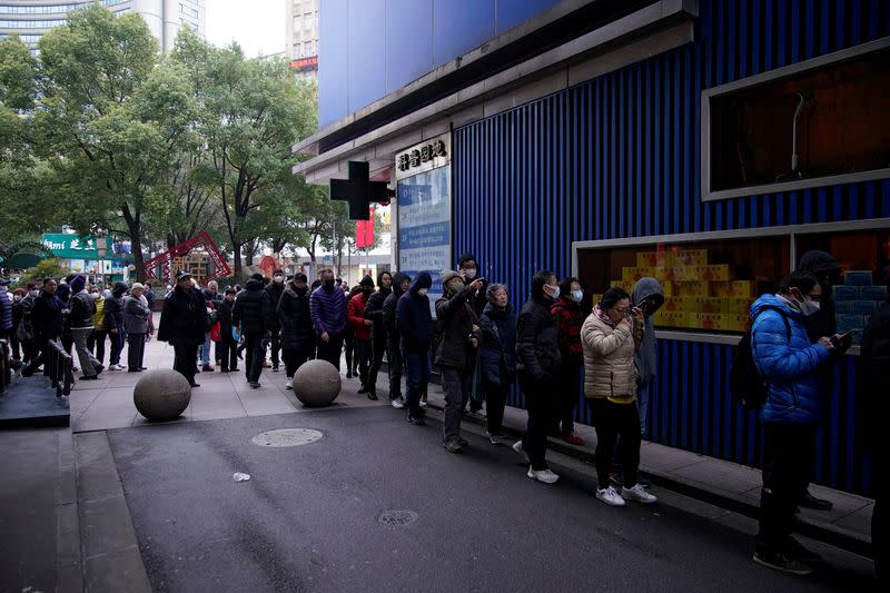 People line up outside a drugstore to buy masks in Shanghai