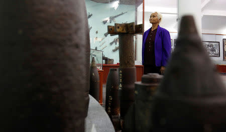 Pham Thi Thuan, My Lai massacre survivor, stands near US weapons in a museum during the 50th anniversary of the My Lai massacre in My Lai village, Vietnam March 15, 2018. REUTERS/Kham