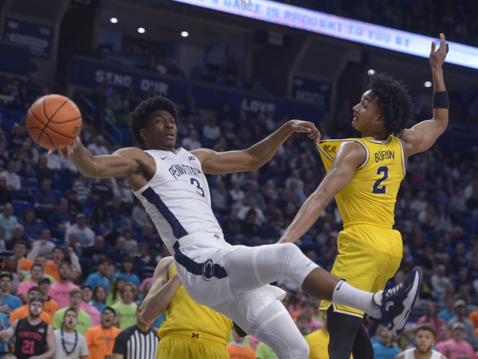 Penn State's Kebba Njie (3) falls pulling down a rebound with Michigan's Kobe Bufkin (2) during the first half of an NCAA college basketball game, Sunday, Jan. 29, 2023, in State College, Pa. (AP Photo/Gary M. Baranec)