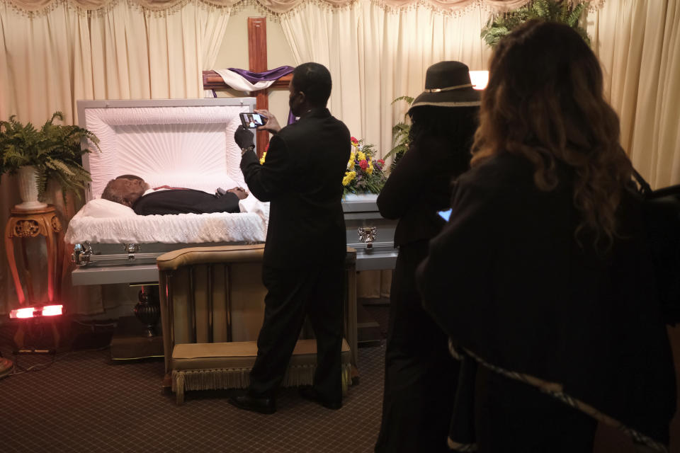 Miembros de la familia de Servius Collin, que falleció de COVID-19, lo acompañan cerca del féretro el jueves 30 de abril de 2020 en la funeraria The Family en Newark, Nueva Jersey. Las familias han tenido que honrar a sus muertos a distancia y en pequeños grupos durante los tiempos actuales de distanciamiento social. (AP Foto/Seth Wenig)