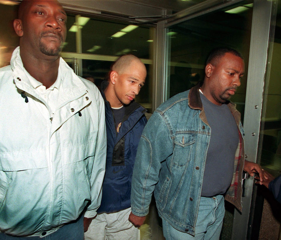 Rae Carruth, center, walks away from the Mecklenburg County Jail after making bond on Dec. 6, 1999, in Charlotte, North Carolina. (Getty)