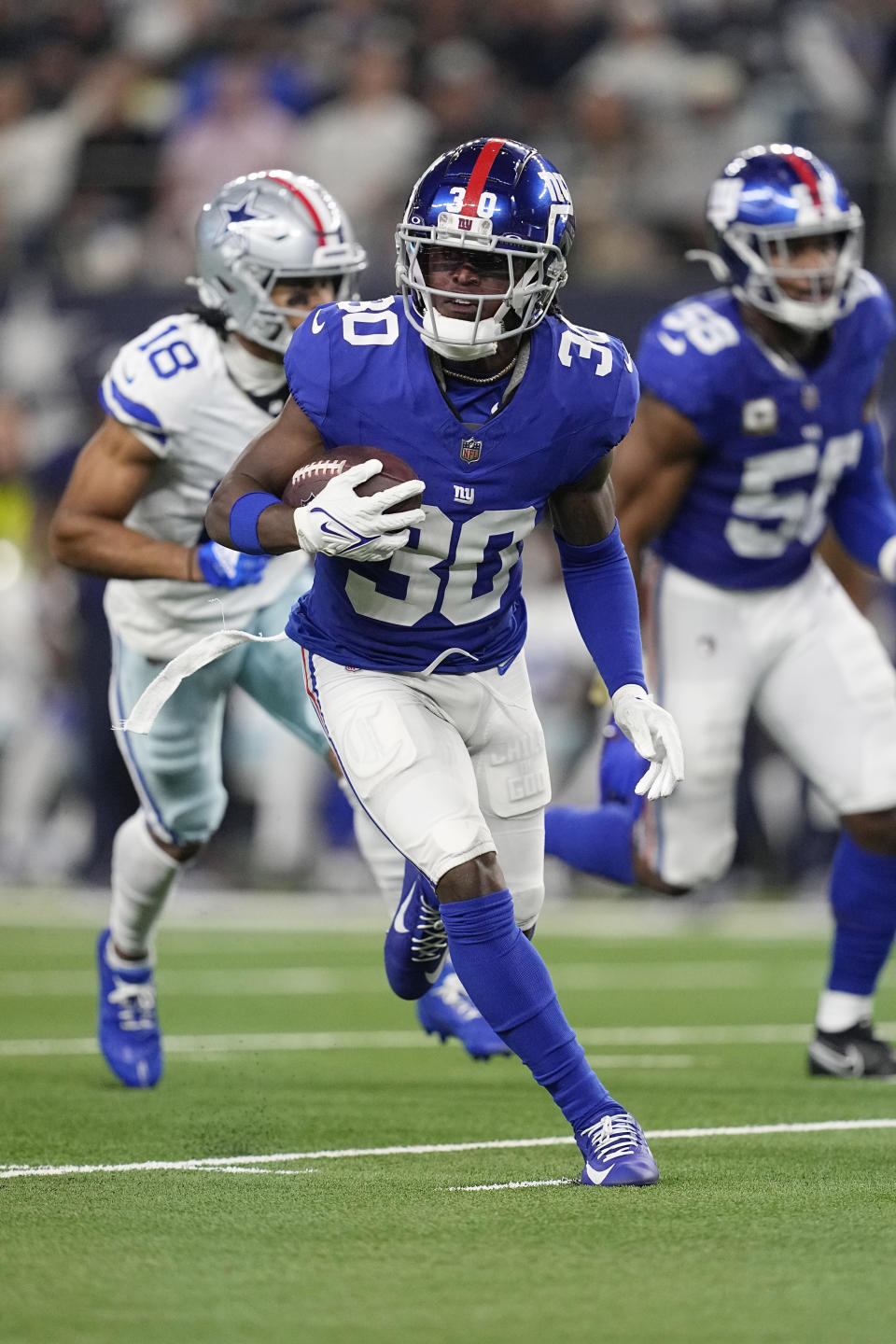 New York Giants cornerback Darnay Holmes (30) runs with the ball after intercepting a pass in the second half of an NFL football game against the Dallas Cowboys, Sunday, Nov. 12, 2023, in Arlington, Texas. (AP Photo/Tony Gutierrez)