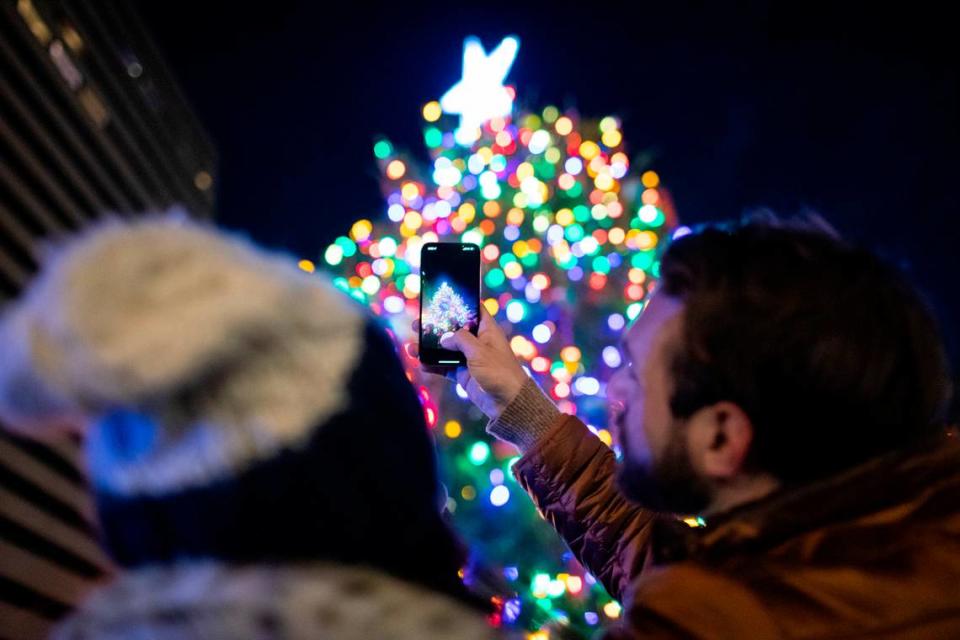 People took photos after the Christmas tree was lit Sunday night at a festival in Triangle Park Sunday night in Lexington.