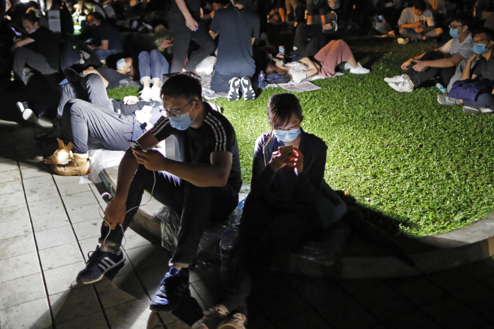 FILE - In this Wednesday, June 12, 2019, file photo, extradition law protesters browse their smartphones near the Legislative Council in Hong Kong. The Hong Kong-based web forum LIHKG and Telegram, the encrypted messaging app, have served as crucial organizing platforms for the largely leaderless protests (AP Photo/Kin Cheung, File)