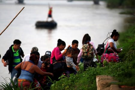 Central American migrants get off a raft after crossing the Suchiate river from Tecun Uman, in Guatemala, to Ciudad Hidalgo, as seen from Ciudad Hidalgo