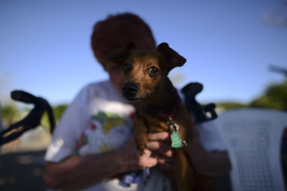 Maria Gonzalez holds her dog Luna outside a shelter afraid of aftershocks, after an earthquake in Guanica, Puerto Rico, Tuesday, Jan. 7, 2020. A 6.4-magnitude earthquake struck Puerto Rico before dawn on Tuesday, killing one man, injuring others and collapsing buildings in the southern part of the island. (AP Photo/Carlos Giusti)