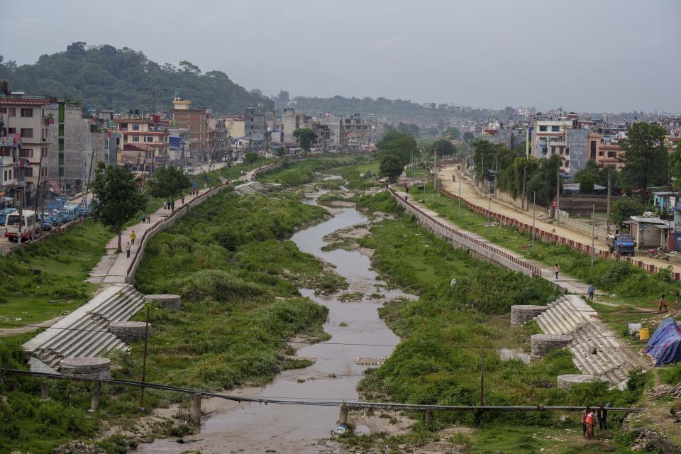 El río Bagmati en un tramo a su llegada a Katmandú, Nepal, el martes 24 de mayo de 2022. Contaminado por la basura y las aguas negras que son vertidas directamente en la vía fluvial, el río más sagrado de Nepal se ha deteriorado tanto que hoy es también el más contaminado del país, lo que altera drásticamente cómo la ciudad de tres millones de habitantes interactúa con el Bagmati en un nivel cultural y espiritual en el día a día. (AP Foto/Niranjan Shrestha)