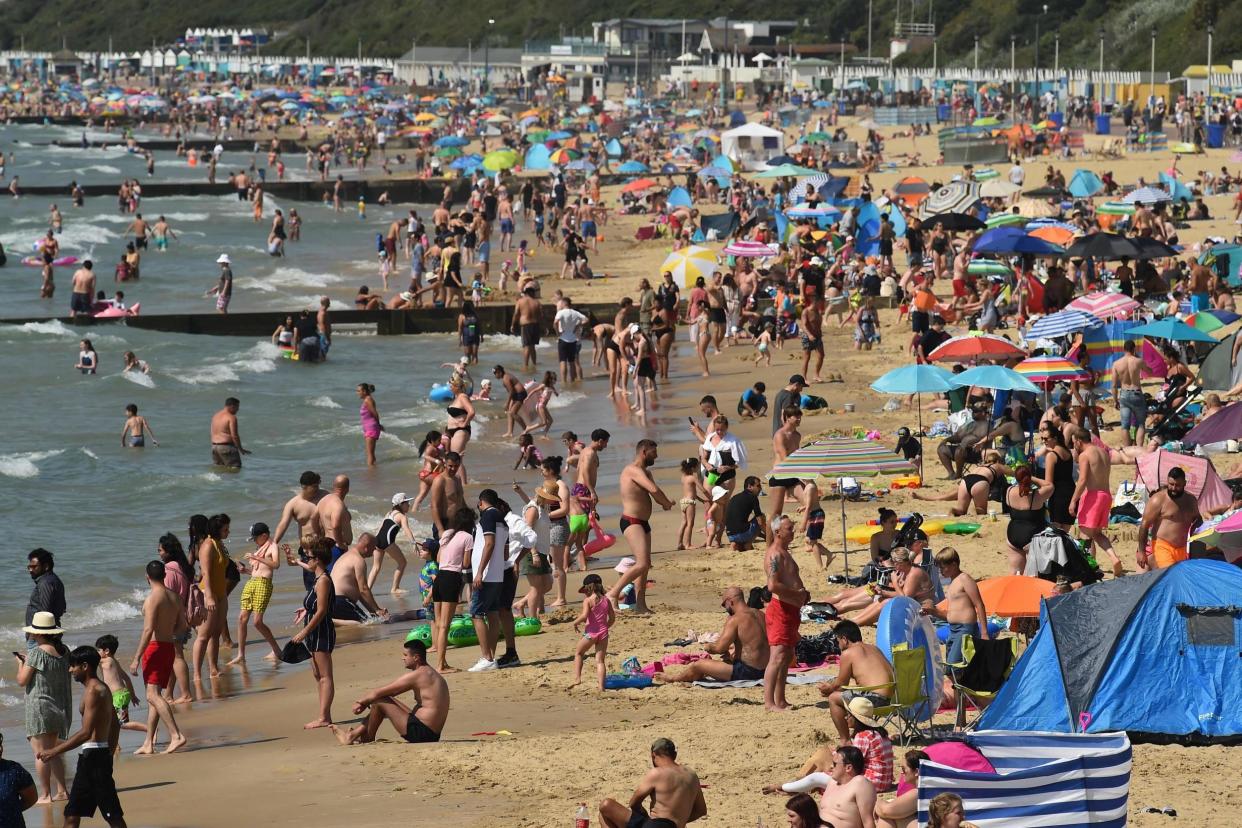 Beachgoers enjoy the sunshine as they sunbathe and play in the sea on Bournemouth beach in Bournemouth, southern England on July 31, 2020: AFP via Getty Images