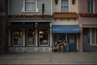 In this Oct. 11, 2019 photo, visitors sits outside a shop on the Main Street at Hong Kong Disneyland in Hong Kong. The body-blow of months of political protests on Hong Kong’s tourism is verging on catastrophic for one of the world’s great destinations. Geared up to receive 65 million travelers a year, the city’s hotels, retailers, restaurants and other travel-oriented industries are suffering. But some intrepid visitors came specifically to see the protests and are reveling in deep discounts and unusually short lines at tourist hotspots. (AP Photo/Felipe Dana)