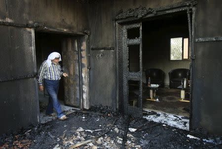 A Palestinian man inspects a house that was badly damaged from a suspected attack by Jewish extremists on two houses at Kafr Duma village near the West Bank city of Nablus July 31, 2015. REUTERS/Abed Omar Qusini