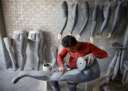 A worker fixes the leg of a mannequin at a workshop in El Kharqanya village, El-Kalubia governorate, north of Cairo, Egypt, March 29, 2017. REUTERS/Amr Abdallah Dalsh