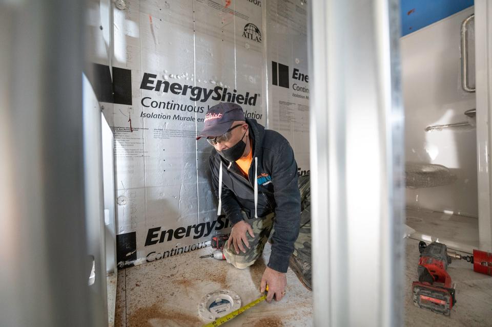 Ronnie Martinez works on the plumbing portion of the construction of the modular homes at indieDwell in 2021.