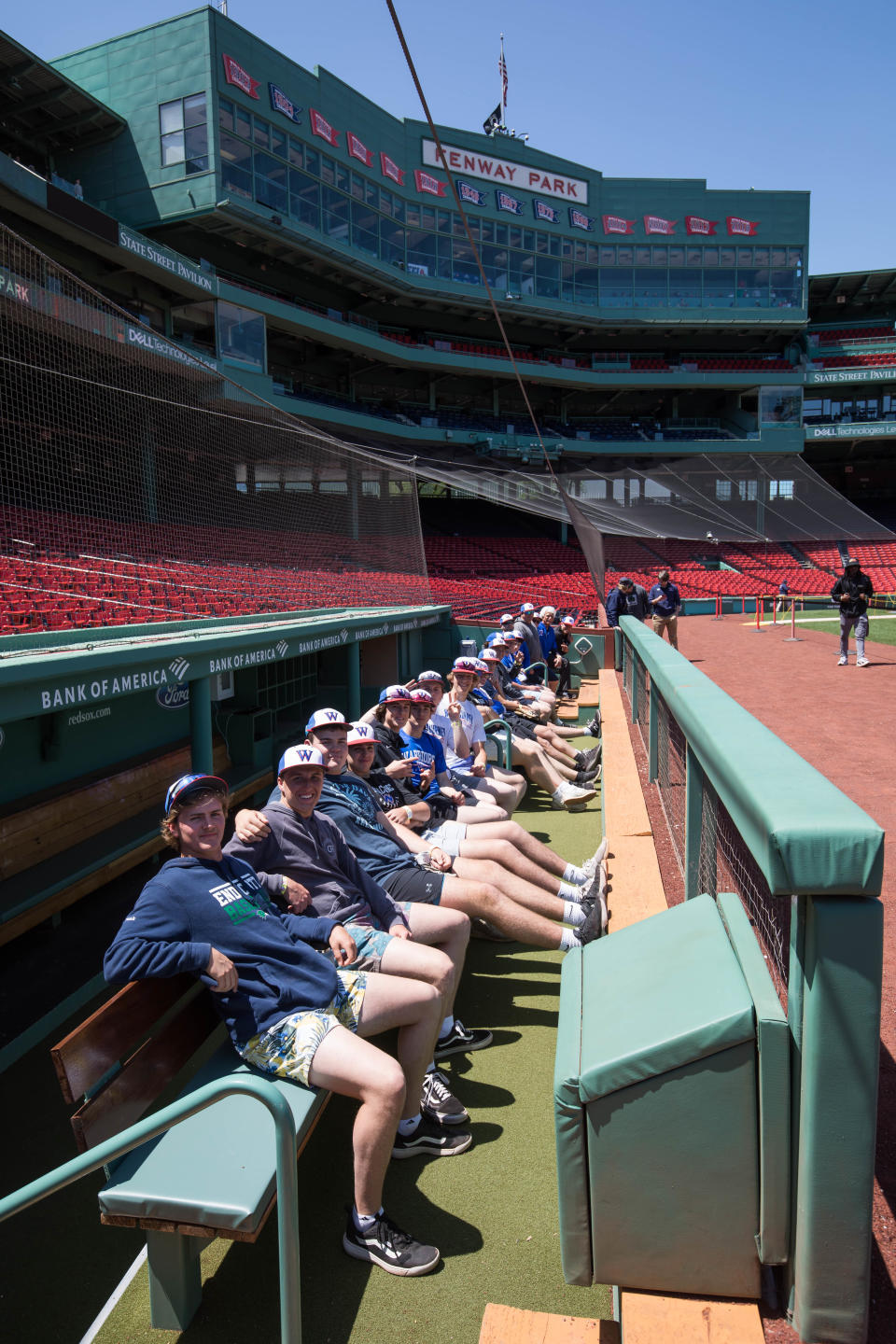 Members of the Winnacunnet High School baseball team take a seat in the Boston Red Sox dugout during Friday's batting practice session at Fenway Park.