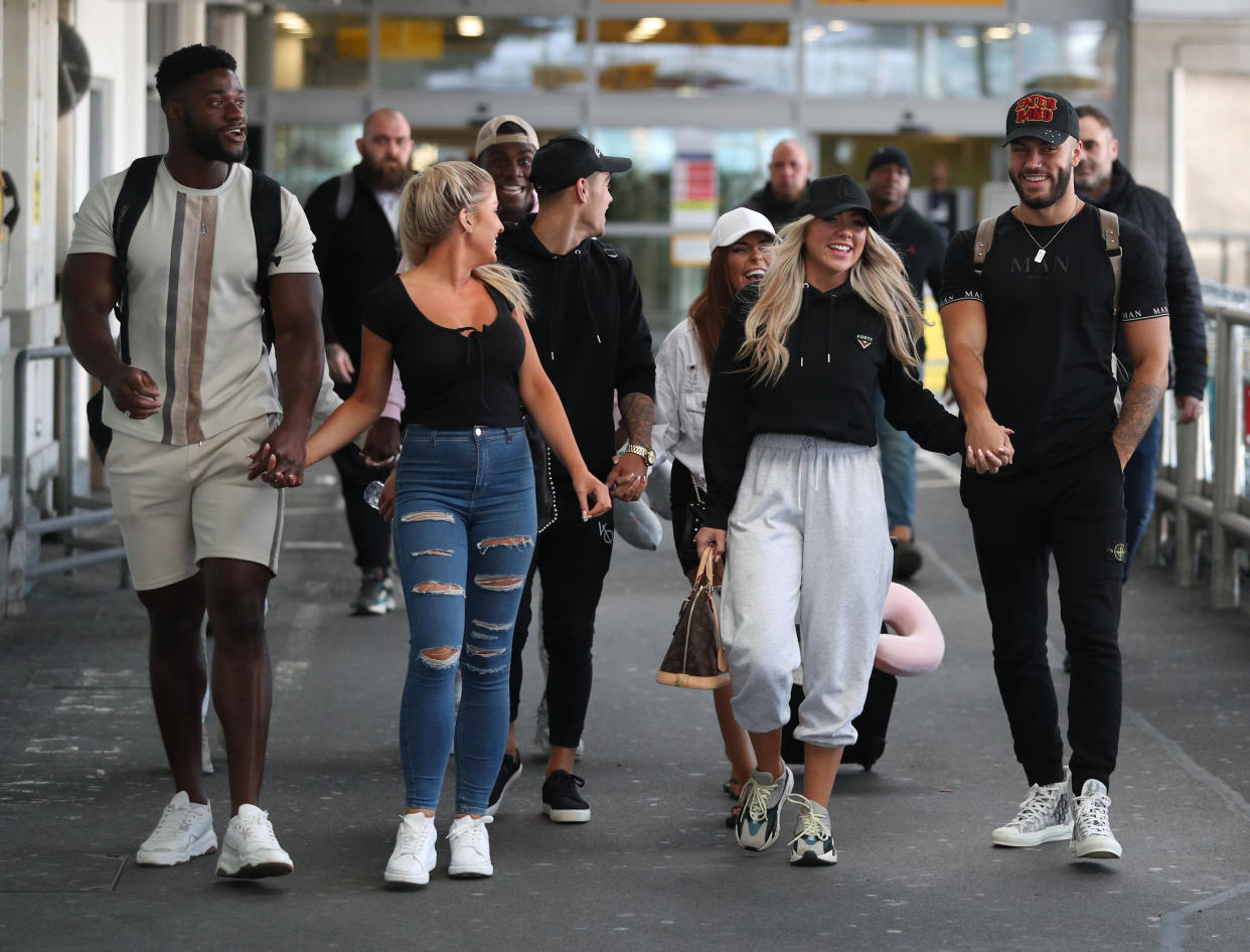 Love Island contestants (couples left to right) Jess Gale and Ched Uzor, Siannise Fudge and Luke Trotman (see rear partially hidden), Luke Mabbott and Demi Jones (centre) and winners Finley Tapp and Paige Turley, walk together after arriving at Heathrow Airport in London following the final of the reality TV show. (Photo by Andrew Matthews/PA Images via Getty Images)