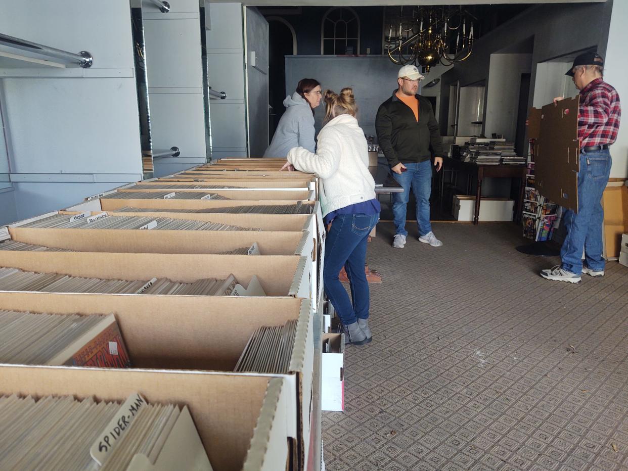 Shoppers peruse boxes of comics during Wolverine Comics' fire sale Thursday. The comic shop is raising money to relocate following a fire at Kelly Square in October.