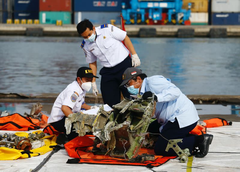 FILE PHOTO: Officers of Indonesia's National Transportation Safety Committee inspect the debris of Sriwijaya Air flight SJ 182, which crashed into the Java Sea, on the last day of its search and rescue operation, at Tanjung Priok port in Jakarta