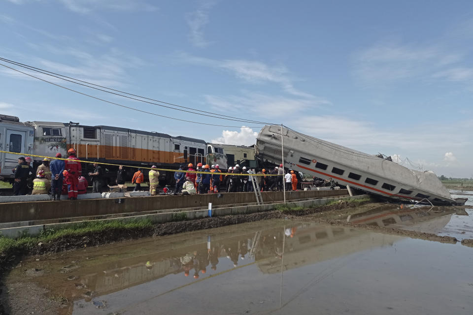 Rescuers inspect the wreckage of trains after a collision in Cicalengka, West Java, Indonesia, Friday, Jan. 5, 2024. The two trains collided on Indonesia's main island of Java on Friday, causing several carriages to buckle and overturn and killing a number of people, officials said. (AP Photo/Abdan Syakura)