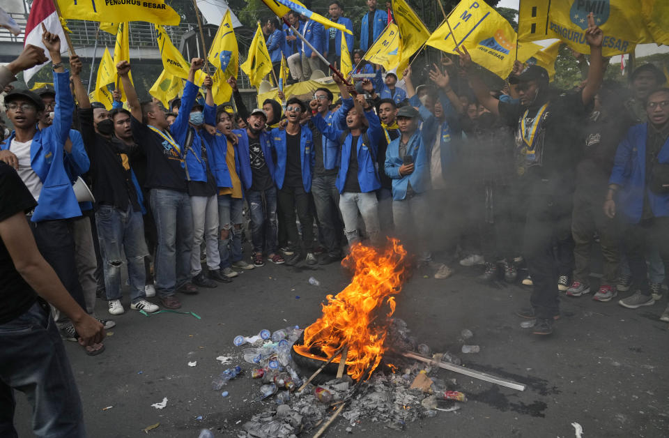 Student activists burn tyre during a rally against fuel price hikes in Jakarta, Indonesia, Monday, Sept. 5, 2022. Fuel prices increased by about 30 percent across Indonesia on Saturday after the government reduced some of the costly subsidies that have kept inflation in Southeast Asia's largest economy among the world's lowest. (AP Photo/Tatan Syuflana)