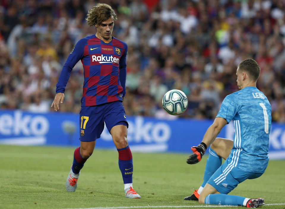 FC Barcelona's Antoine Griezmann, left, vies for the ball with Arsenal's goalkeeper Bernd Leno during the Joan Gamper trophy soccer match between FC Barcelona and Arsenal at the Camp Nou stadium in Barcelona, Spain, Sunday, Aug. 4, 2019. (AP Photo/Joan Monfort)