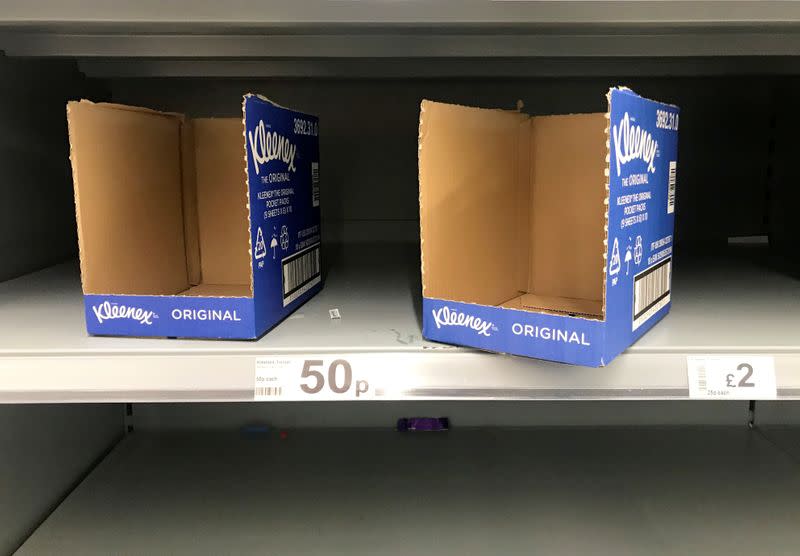 Empty shelves and empty packaging boxes for Kleenex tissues are seen inside an Asda supermarket in Milton Keynes