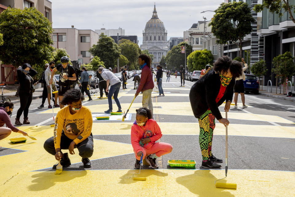 People participate in a project to paint massive letters spelling 