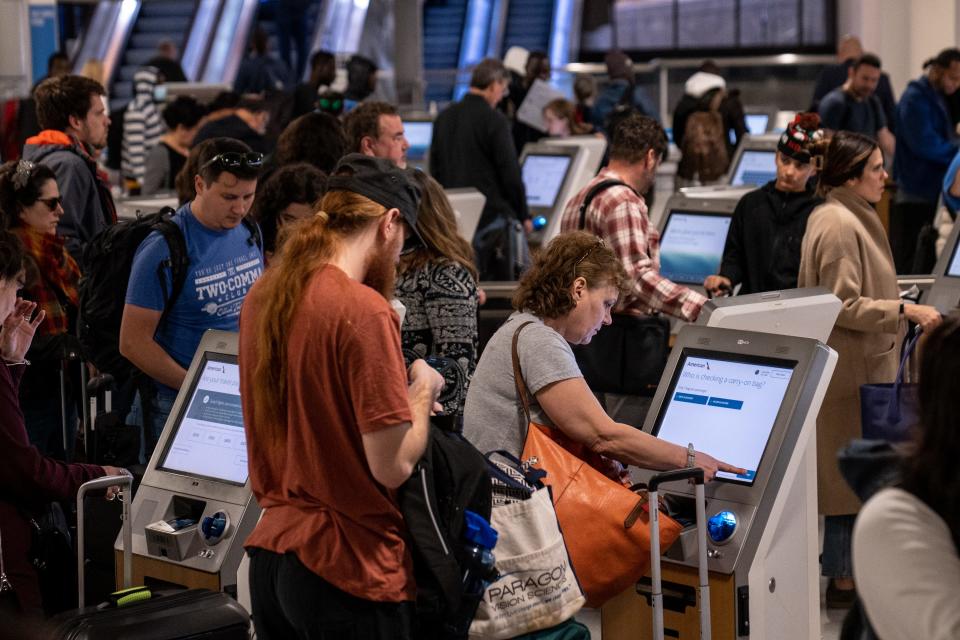 People check in for their flights at Terminal 4 at Phoenix Sky Harbor International Airport in Phoenix on Dec. 21, 2023.