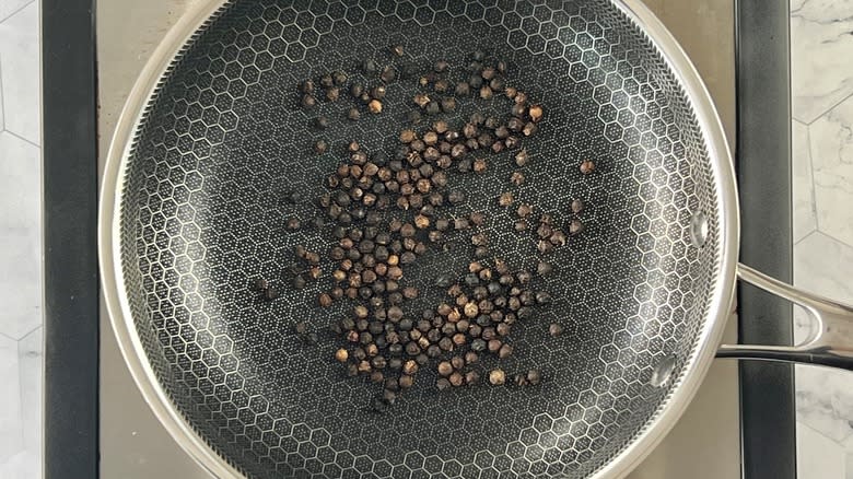 black peppercorns toasting in pan