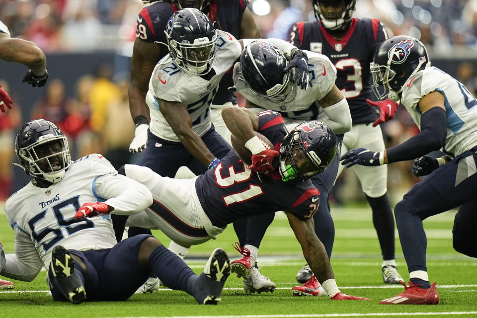 Houston Texans running back Dameon Pierce (31) is stopped by Tennessee Titans defenders during the first half of an NFL football game Sunday, Oct. 30, 2022, in Houston. (AP Photo/Eric Gay)