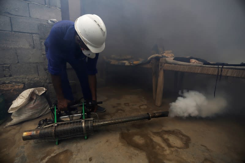 Health worker fumigates a residential area to curb the spread of dengue fever in Hodeidah