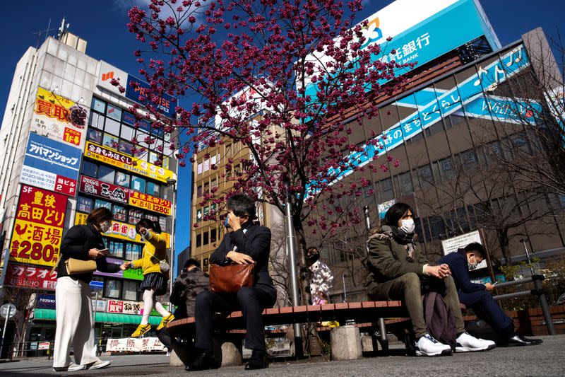 FILE PHOTO: People wearing face masks are seen in front of Nakano station in Tokyo as Japan tackles the outbreak of coronavirus