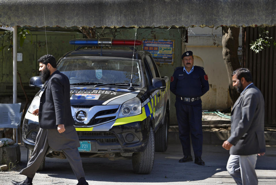Worshipers walk past a police vehicle stationed outside a mosque belonging to a banned religious group in Islamabad, Pakistan, Wednesday, March 6, 2019. Pakistan on Wednesday continued a crackdown on seminaries, mosques and hospitals belonging to outlawed groups, saying the actions were part of the government efforts aimed at fighting terrorism, extremism and militancy. (AP Photo/Anjum Naveed)