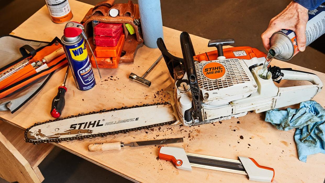 roy performing maintenance on a gas powered chainsaw