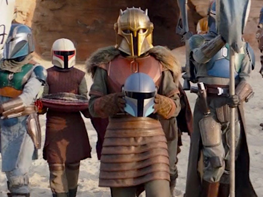 Emily Swallow as the Armorer surrounded by other Mandalorians.