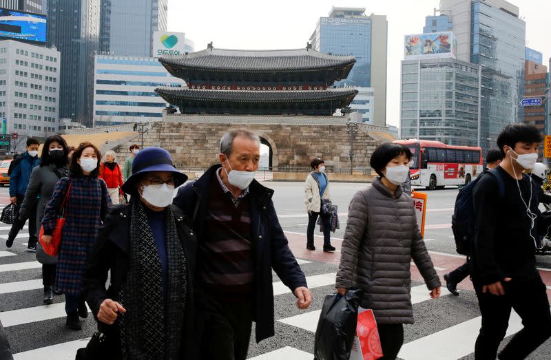People wearing masks to prevent contracting the coronavirus cross a street in downtown Seoul