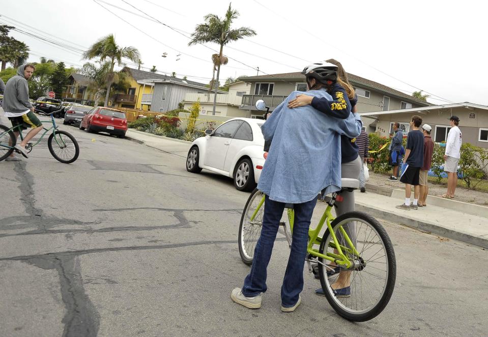 A couple comfort each other after a series of drive -by shootings that left 6 people dead in the Isla Vista section of Santa Barbara,