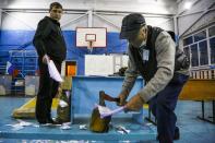 Members of an election commission destroy unused ballots after voting at a polling station after the Parliamentary elections in Nikolayevka village outside Omsk, Russia, Sunday, Sept. 19, 2021. From the Baltic Sea to the Pacific Ocean, Russians across eleven time zones voted Sunday on the third and final day of a national election for a new parliament, a ballot in which the pro-Kremlin ruling party is largely expected to retain its majority after months of relentless crackdown on the opposition. (AP Photo/Evgeniy Sofiychuk)