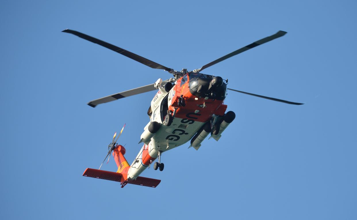 A U.S. Coast Guard helicopter flies over the Venice Fishing Pier Thursday morning as emergency crews search a debris field in the Gulf of Mexico after a small airplane crash Wednesday night. The bodies of two men in their 50s-60s have been recovered. 