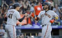 San Francisco Giants' Wilmer Flores (41) congratulates Brendan Crawford after Crawford's three-run home run in the ninth inning of a baseball game against the Colorado Rockies in Denver, Sunday, Sept. 26, 2021. San Francisco won 6-2. (AP Photo/Joe Mahoney)