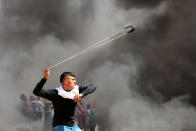 <p>A Palestinian protester uses a sling shot during clashes with Israeli toops near the border with Israel in the east of Jabaliya refugee camp in the northern Gaza Strip, April 6, 2018. (Photo: Momen Faiz/NurPhoto via Getty Images) </p>