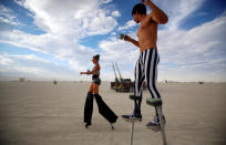 <p>Katapult Sandra (L) and Divine Mustache, their Playa names, dance on stilts as approximately 70,000 people from all over the world gather for the 30th annual Burning Man arts and music festival in the Black Rock Desert of Nevada, Aug. 29, 2016. (REUTERS/Jim Urquhart)</p>