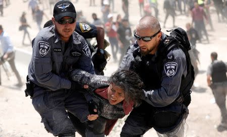 FILE PHOTO: Israeli policemen detain a Palestinian girl in the Palestinian Bedouin village of al-Khan al-Ahmar near Jericho in the occupied West Bank July 4, 2018. REUTERS/Mohamad Torokman