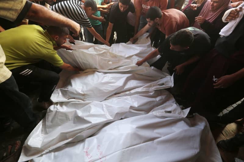 Palestinians mourn over the bodies of their relatives, who were killed in an Israeli attack, after the bodies have been brought to the al-Aqsa Martyrs Hospital for burial in Deir al-Balah. Omar Ashtawy/APA Images via ZUMA Press Wire/dpa