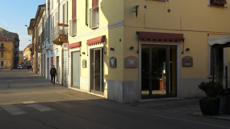 People walk down an empty street in the village of Codogno after officials told residents to stay home and suspend public activities as 14 cases of coronavirus are confirmed in northern Italy