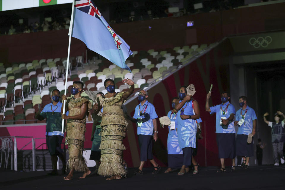 Rusila Nagasau and Jerry Tuwai, of Fiji, carry their country's flag during the opening ceremony in the Olympic Stadium at the 2020 Summer Olympics, Friday, July 23, 2021, in Tokyo, Japan. (Hannah McKay/Pool Photo via AP)