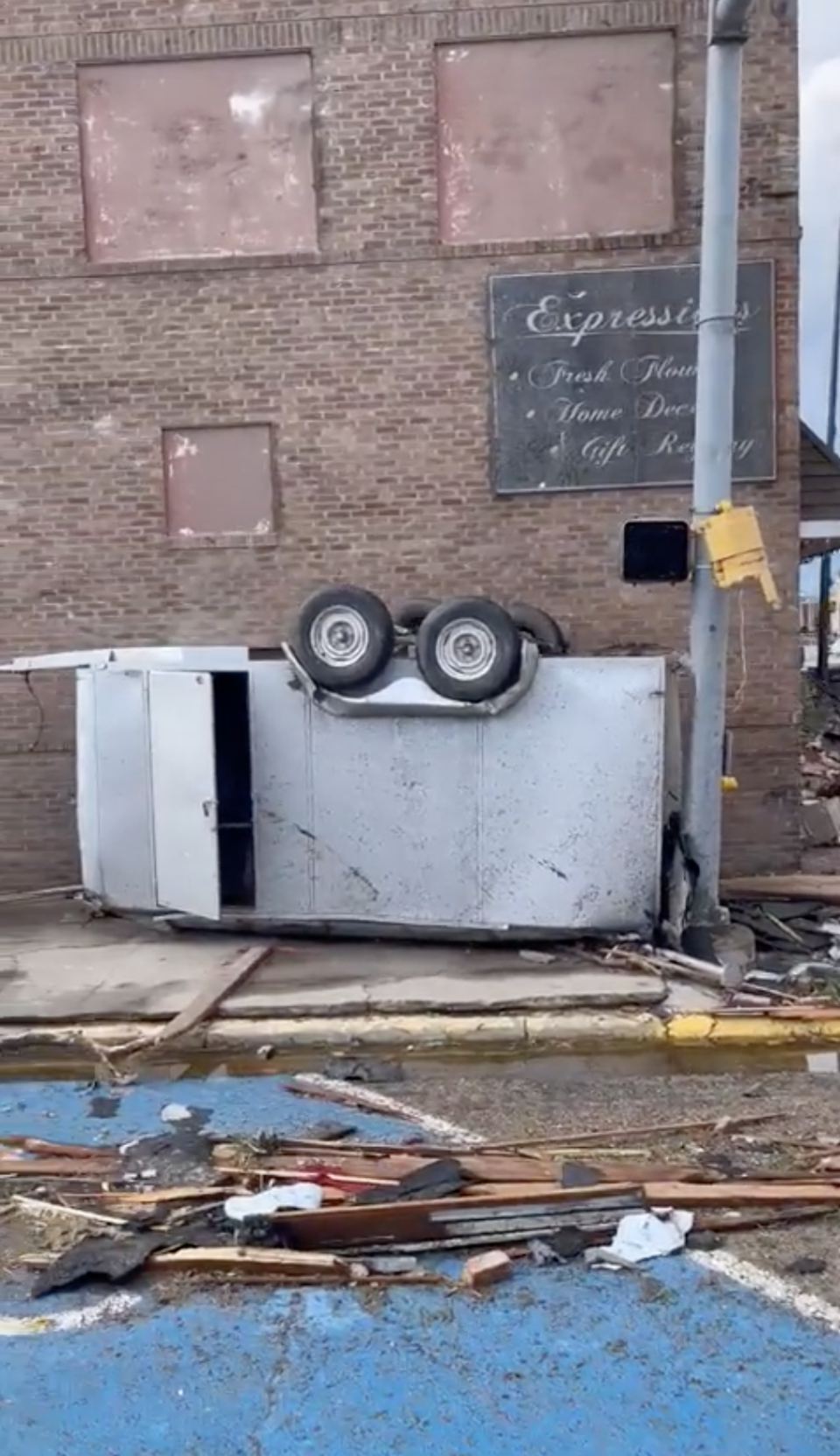 A vehicle on its side amid debris