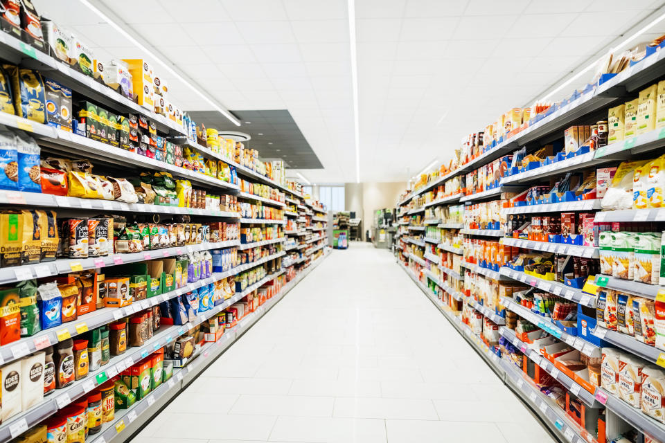 A colorful supermarket aisle withe no people but an abundance of food.