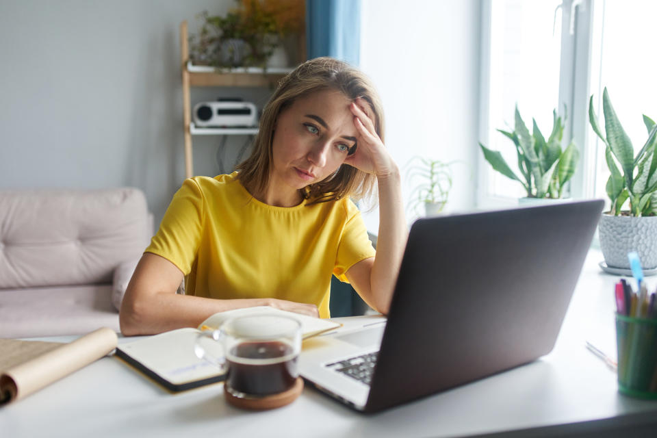 Woman looks at her computer with concern