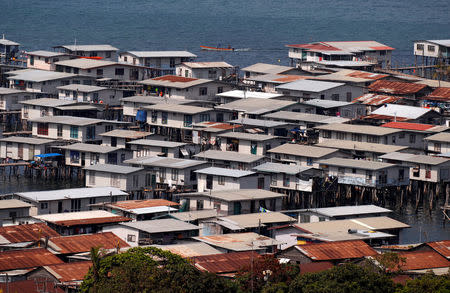 A small boat travels past the stilt house village called Hanuabada, located in Port Moresby Harbour, Papua New Guinea, November 19, 2018. REUTERS/David Gray