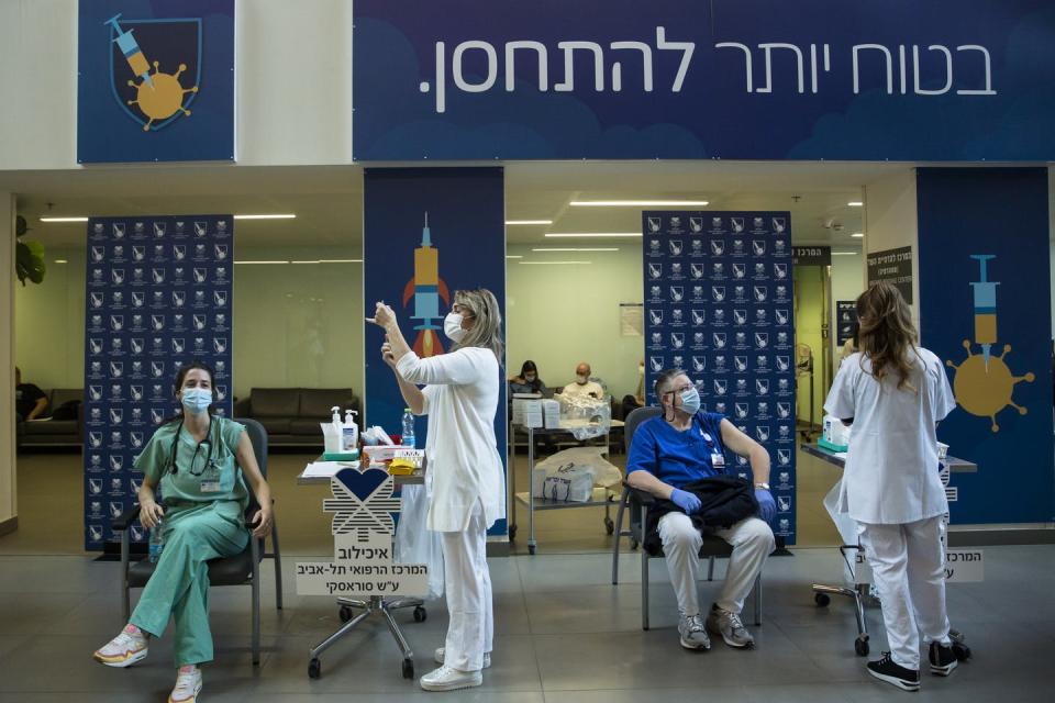 Nurses prepare to give medical workers vaccines.